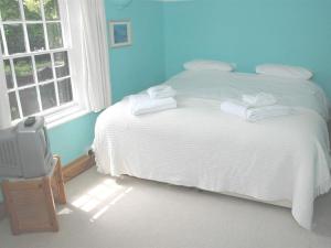 a bedroom with a white bed and a window at The White House in Takeley