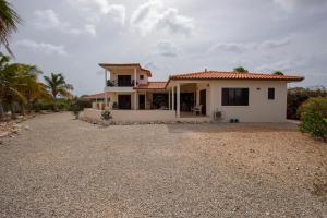 a house with a gravel driveway in front of it at Casa Coco Bonaire at Sabalpalm Villas in Kralendijk