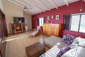 a living room with red walls and a couch at Casa Coco Bonaire at Sabalpalm Villas in Kralendijk