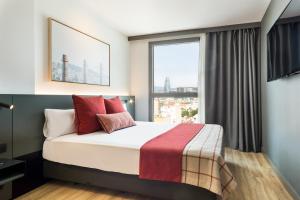 Un dormitorio con una cama y una ventana grande. en Acta Voraport, en Barcelona