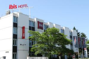 a hotel with a sign on the side of a building at ibis Saint-Denis Stade Ouest in Saint-Denis