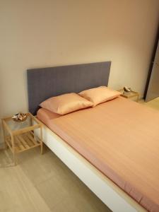 Karditsa Home Sweet Home 80 τ.μ في كارديتسا: سرير مع اللوح الأمامي رمادي وطاولة جانبية