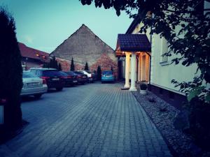 a cobblestone street with cars parked on it at Pensiunea Casa Moga in Bucium +89 photos