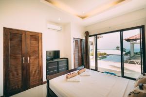 a bedroom with a bed and a view of the ocean at Lilu Villa In Lamai in Lamai