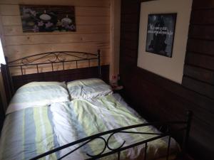 a bed in a room with a wooden wall at Ferienhaus im fränkischen Seenland - Altmühltal in Eichstätt