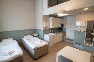 a small room with two beds and a kitchen at Innotelli Apartments in Helsinki