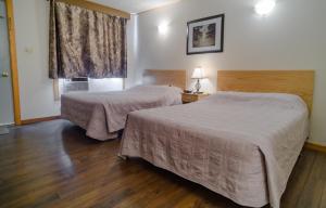 um quarto de hotel com duas camas e uma janela em Winds Motel em Montague