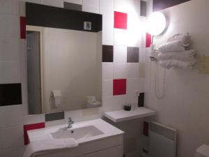 a bathroom with a sink and a mirror at Hotel Les Gravades Ussel in Ussel