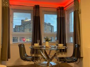 a dining room with a table and chairs and a window at The Beach Apartment, near Outlander location in Kirkcaldy