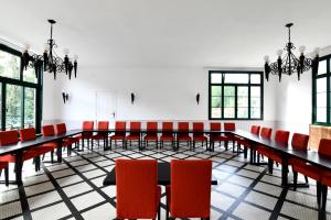 a conference room with tables and red chairs at H&ocirc;tel Restaurant Du Ch&acirc;teau in Josselin