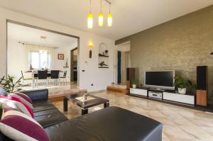 a living room with a couch and a tv at Villa Rose in Rovinj