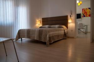 een slaapkamer met een bed en een houten vloer bij Ponte di Cecco appartamenti in Ascoli Piceno