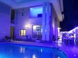 a house with a swimming pool at night at Presken Hotel @Oniru in Lagos