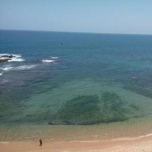 a person standing on a beach near the ocean at Pier Sul Apartaments in Salvador