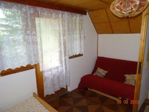 salon z czerwoną kanapą i oknem w obiekcie Chata Kamberk w mieście Kamberk