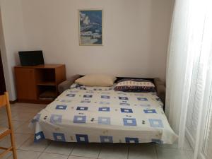 1 dormitorio con 1 cama con edredón azul y blanco en Apartments L.Z. en Starigrad-Paklenica