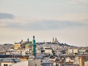 a view of the city of paris with a statue at Le Meurice – Dorchester Collection in Paris
