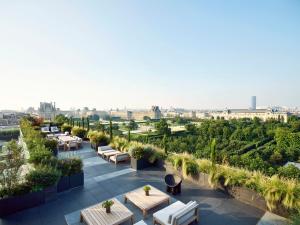 a rooftop patio with tables and a view of the city at Le Meurice – Dorchester Collection in Paris