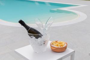 - une bouteille de champagne dans un seau à côté d'un bol de glace dans l'établissement Casolare La Quercia, à Correzzola