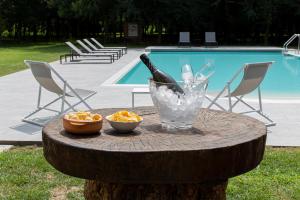 - une table en bois avec une bouteille de vin et un bol de fruits dans l'établissement Casolare La Quercia, à Correzzola
