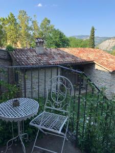 a chair and a table in front of a building at La Locanda Della Campanara in Santa Sofia