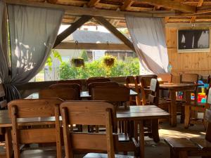 a dining room with wooden tables and chairs at Villa Lukash in Yanoshi