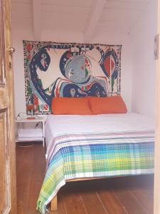 Ce lit se trouve dans un dortoir orné d'une peinture murale. dans l'établissement Convento Senhora da Vitoria - Budget, à Castelo de Vide