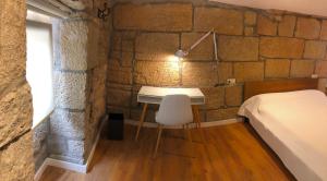 a bedroom with a bed and a desk in a room at Casa Boutique Marín 1910 in Marín