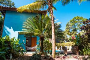 una casa con palmeras y una hamaca al aire libre en Pousada Bambu, en Itacaré