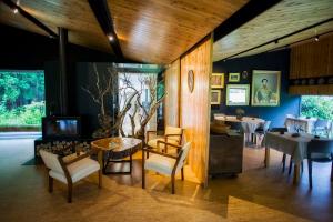 a living room with a table and chairs and a television at Furnas Lake Forest Living in Furnas