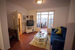 - un salon avec un canapé bleu et une table dans l'établissement Casa dos Limoeiros, à Évora