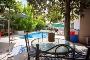 a glass table and chairs in front of a pool at Casa dos Limoeiros in Évora