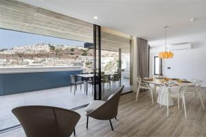 Un comedor y una sala de estar con mesa y sillas. en The One Luxury Apartments, en Puerto Rico de Gran Canaria