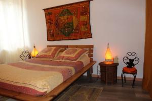 a bedroom with a bed and a tapestry hanging on the wall at Au Coeur de Rennes Chambres d'hôtes in Rennes-les-Bains