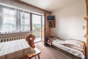 een kamer met een bed en een balkon met een televisie bij Pokoje Gościnne Sarenka - noclegi w pobliżu Tatr in Czarna Góra