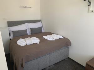 a bedroom with a bed with two towels on it at Botel Gracia in Bratislava