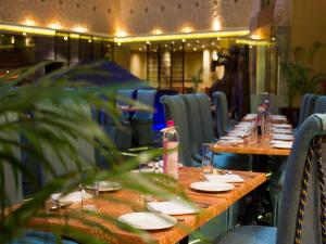 a long table in a restaurant with plates and glasses at Sterlings Mac Hotel in Bengaluru