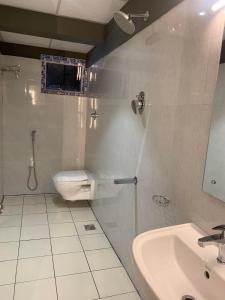 a bathroom with a sink and a toilet and a mirror at Hotel Temple City in Madurai