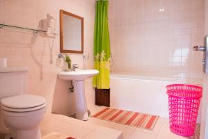 a bathroom with a toilet and a sink and a tub at Calabash Residence Apartments in Kotu