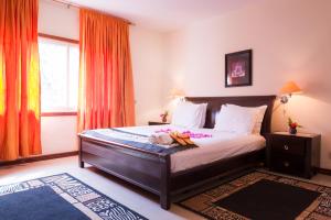 a bedroom with a bed and a large window at Calabash Residence Apartments in Kotu