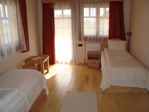 a bedroom with two beds and a window at Pensiunea Sapte Flori in Gheorgheni