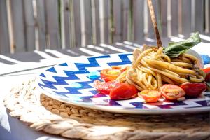 une plaque de pâtes et de tomates sur une table dans l'établissement Gocce Di Capri Resort, à Massa Lubrense