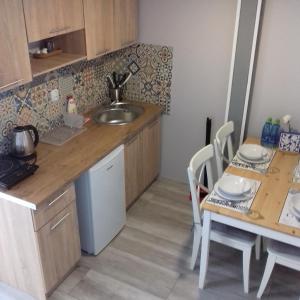 a kitchen with a sink and a table with chairs at Apartamenty Przystań in Międzyzdroje