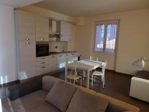 a living room with a couch and a table and a kitchen at Casa Costa Outlet 5 in Serravalle Scrivia