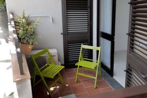2 sillas verdes y una planta en el balcón en La Casa Di Dodo, en Taormina