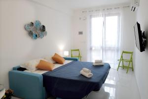 una camera da letto con un letto blu e asciugamani di La Casa Di Dodo a Taormina
