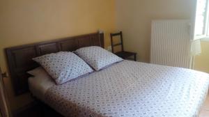 - un lit avec 2 oreillers dans une chambre dans l'établissement Au Coeur de Rennes Gîte, à Rennes-les-Bains