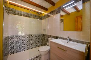 uma casa de banho com um WC, um lavatório e um espelho. em Piscina en Casa Rural con Encanto El Puentuco una de las casas mas valoradas de Cantabria em Villacarriedo