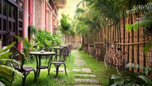an outdoor patio with tables and chairs and bikes at Mane Colonial Classic in Siem Reap