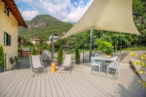 a patio with a table and chairs and a mountain at Sofi apartment in Chiavenna